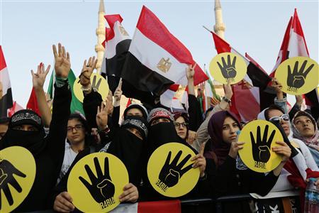 Supporters of Mursi and the Muslim Brotherhood wave Egyptian flags during a rally in protest against the recent violence in Egypt, outside of the Eminonu New mosque in Istanbul